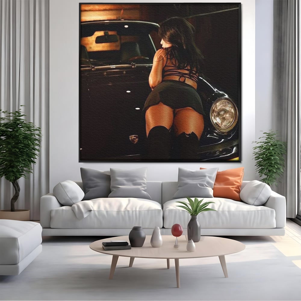 Tablou canvas cu tablou canvas cu femeie pe masina, in rama de aluminiu negru, pe perete intr-un living